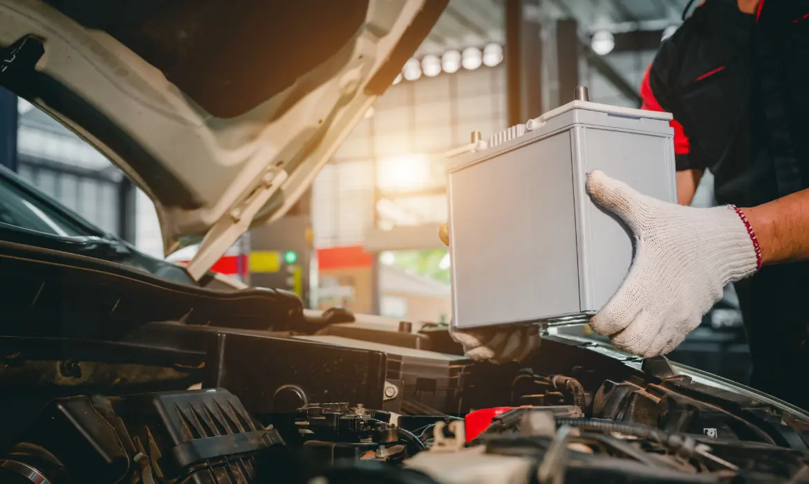 A mechanic replaces a car battery